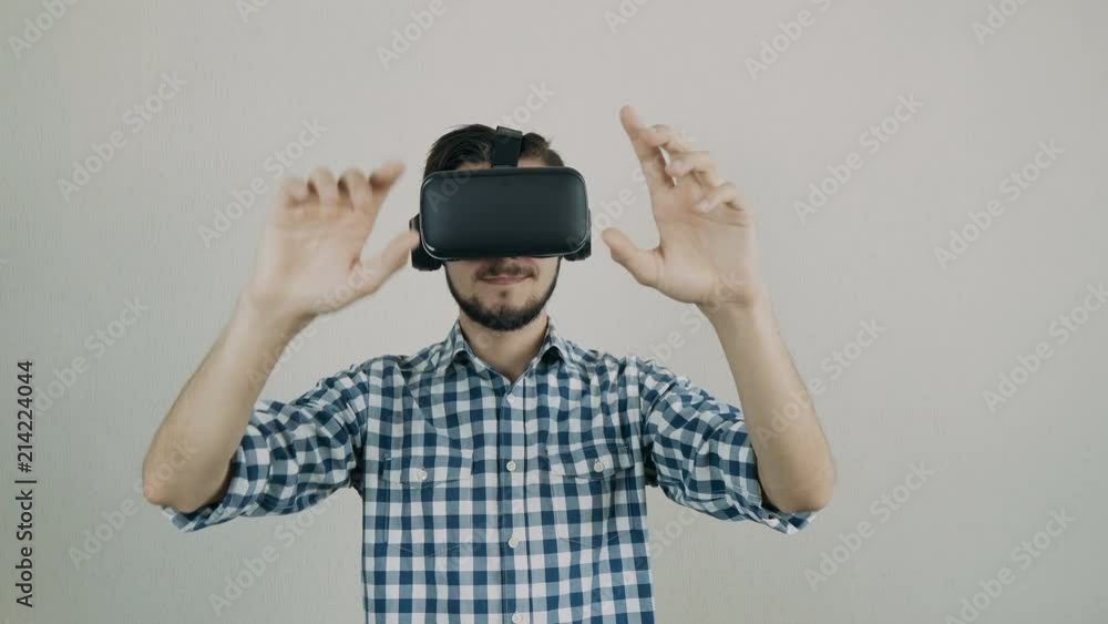 Close up shot of a young bearded man wearing virtual reality glasses - surfing net via virtual reality interface. Close up shot of a young bearded man wearing virtual reality glasses - surfing net via virtual reality interface.