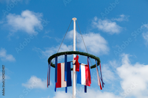 Festive wreath with little flag in front of blue sky