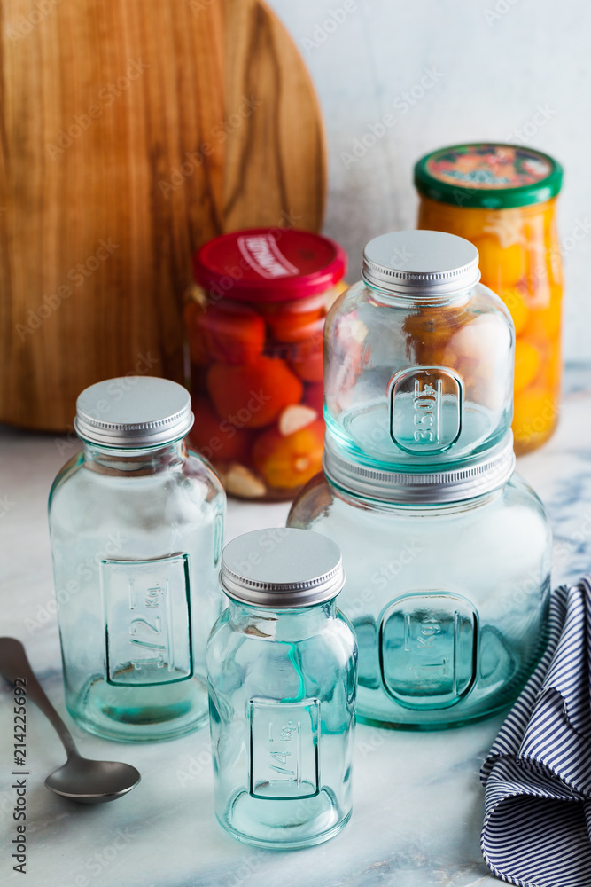 Glass jars, ready for sterilization and canning. preservation of food on a marble table. Glass jars, ready for sterilization and canning. preservation of food on a marble table.