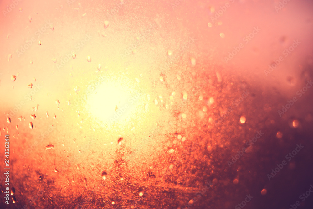 Blurred texture. Sunset after the rain through the glass with droplets, golden sunset.