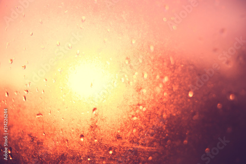 Blurred texture. Sunset after the rain through the glass with droplets, golden sunset.