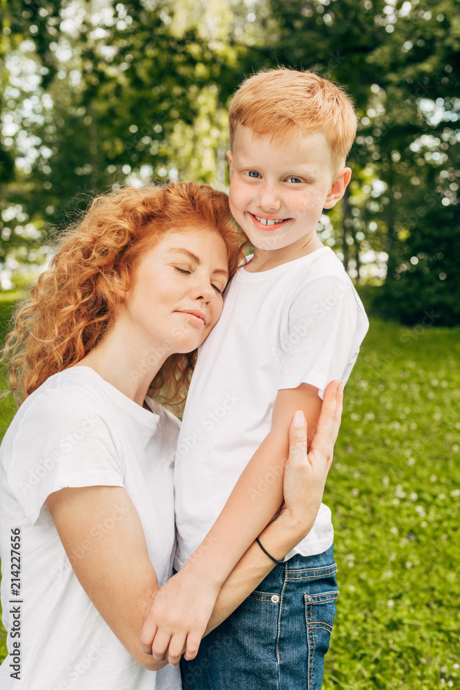 happy young mother hugging adorable little son in park happy young mother hugging adorable little son in park