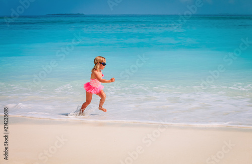 little girl run play with waves on beach