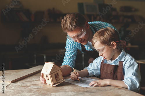 Father and son with a wooden house