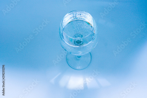 Glass of water on a blue background, lit from the window