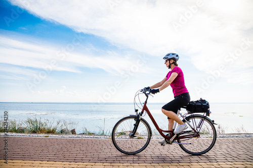 Fototapeta Naklejka Na Ścianę i Meble -  Healthy lifestyle - middle-aged woman riding bicycles
