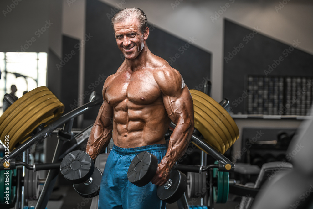 Brutal aged strong bodybuilder athletic men pumping up muscles with dumbbells Brutal aged strong bodybuilder athletic men pumping up muscles with dumbbells