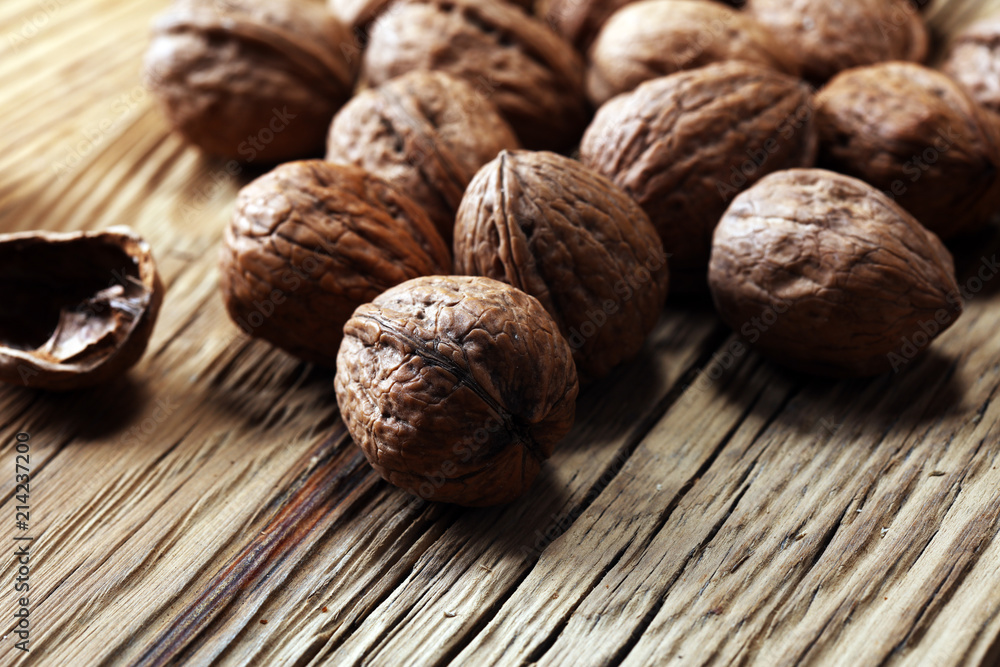 Walnut kernels and whole walnuts on rustic old table. Walnut kernels and whole walnuts on rustic old table.