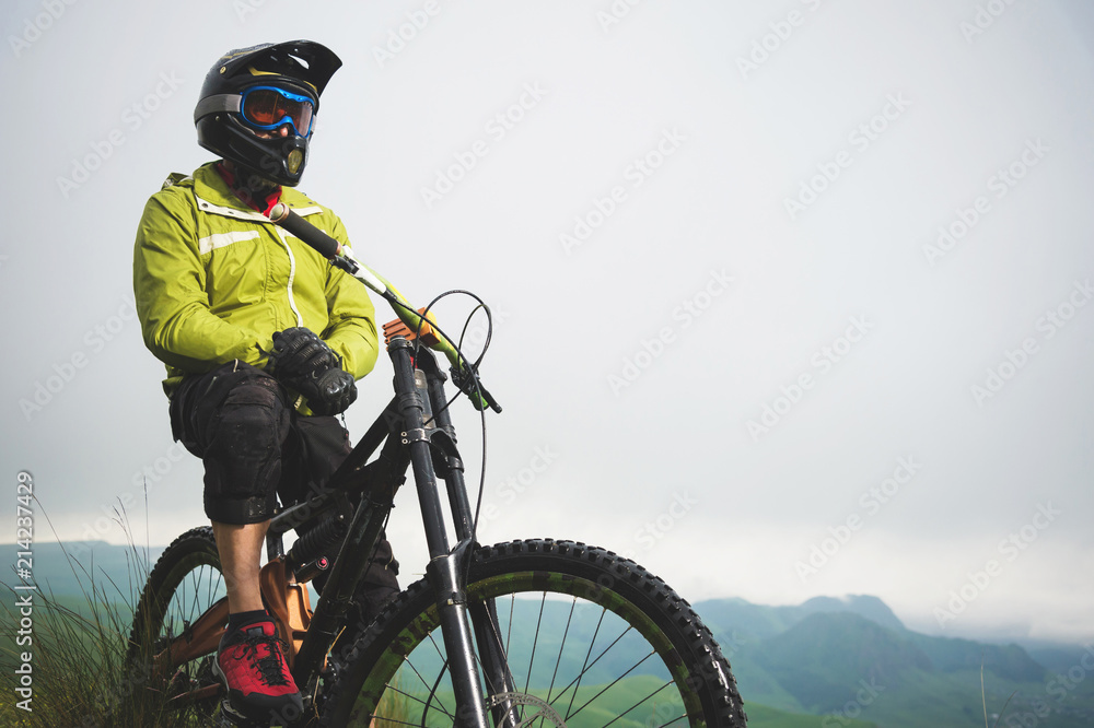 Portrait of a man aged on a mountain bike in the mountains in cloudy weather. Mountain bike concept Portrait of a man aged on a mountain bike in the mountains in cloudy weather. Mountain bike concept