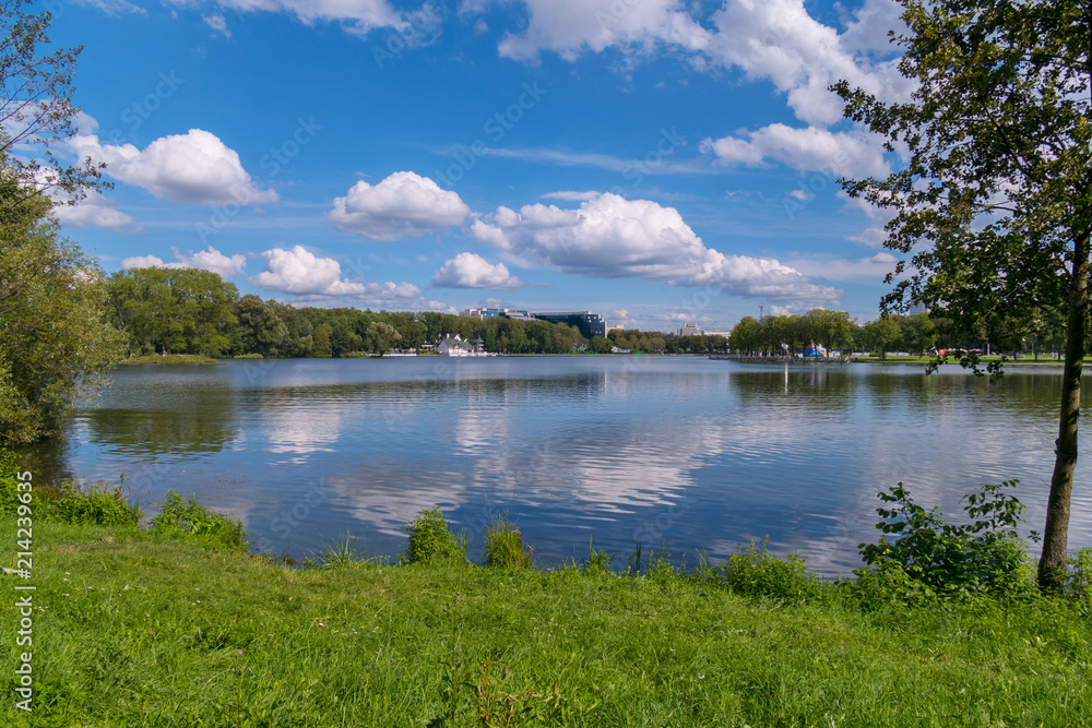 fluffy white clouds float through the blue sky over the calm flat water fluffy white clouds float through the blue sky over the calm flat water
