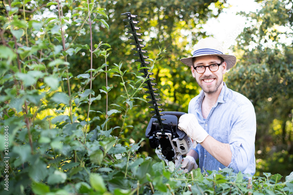Fototapeta premium Mann bei der Gartenarbeit mit einer Heckenschere 