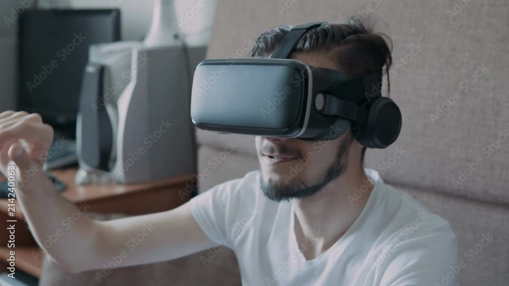 Close up shot of a young bearded man wearing virtual reality glasses - surfing net via virtual reality interface. Close up shot of a young bearded man wearing virtual reality glasses - surfing net via virtual reality interface.