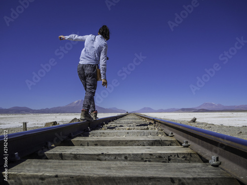 Obraz na płótnie Woman traveler walking into the horizon on a train rail w salonie