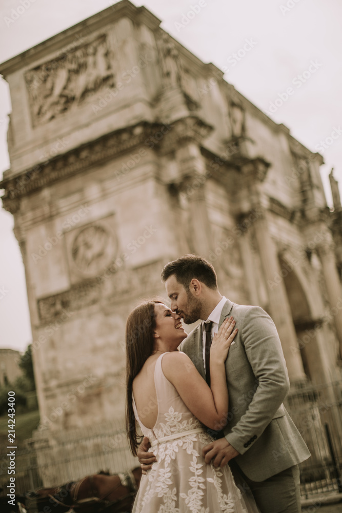 Young wedding couple by Arch of Constantine in Rome