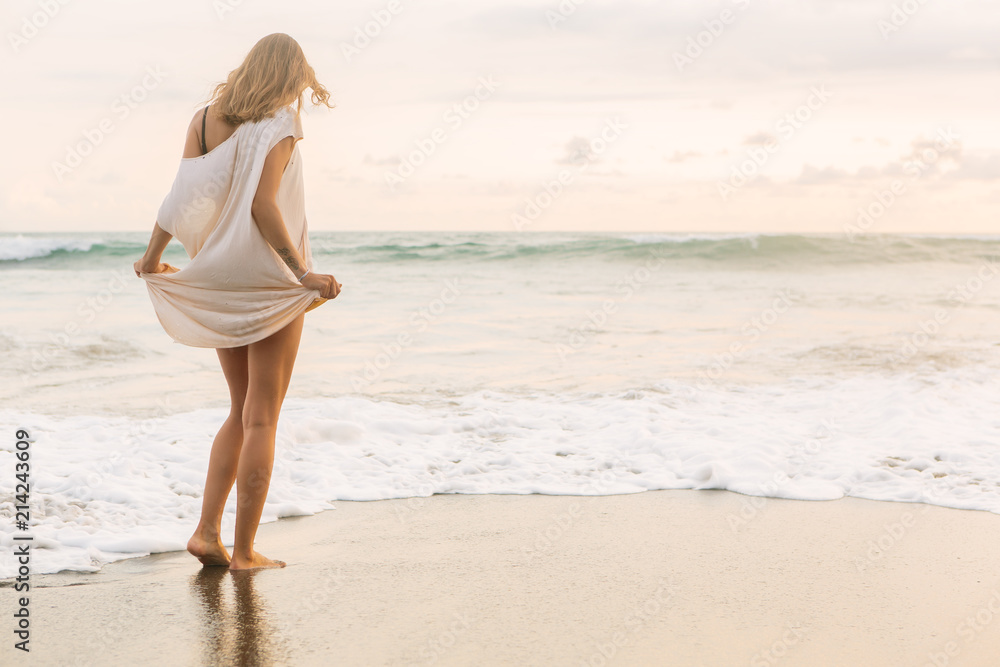 Hipster trendy girl hold her long summer dress and bikini trying not to wet it in waves. Sporty fit lady on sea sand beach sunset or ocean sunrise. Travel, active, yoga, freedom lifestyle concept. Hipster trendy girl hold her long summer dress and bikini trying not to wet it in waves. Sporty fit lady on sea sand beach sunset or ocean sunrise. Travel, active, yoga, freedom lifestyle concept.