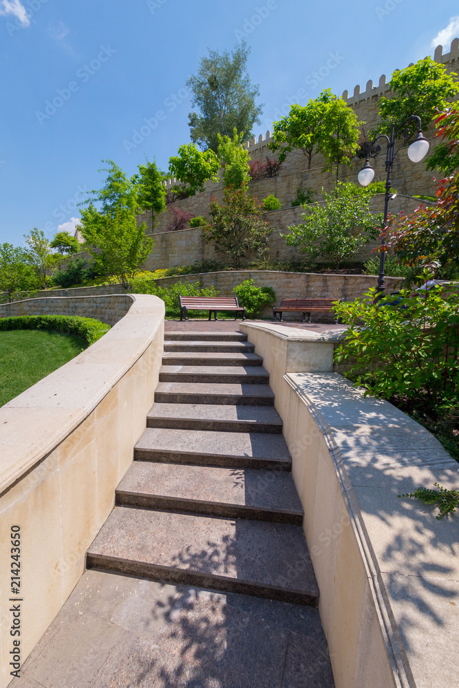 stepped wall with prongs on top with trees planted stepped wall with prongs on top with trees planted