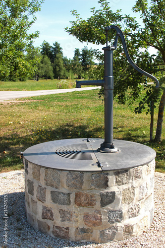 sealed wells with hand pump in an orchard photo