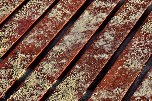 Background of sand on wooden red boards. Stairway of boards on a sandy beach