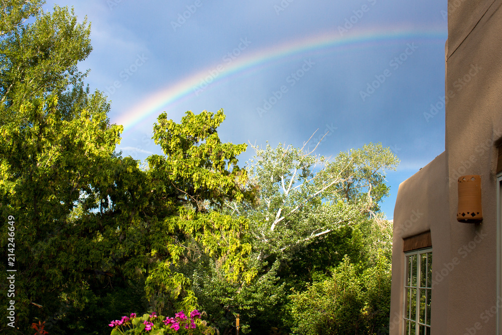 Obraz premium A rainbow over Santa Fe, New Mexico, during the summer rainy season