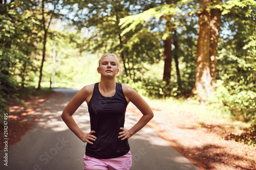 Fit young woman taking a break from her forest run