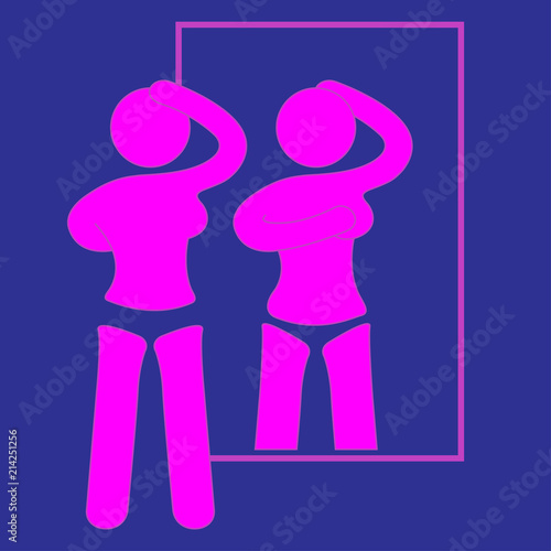 Woman examining her breast in front of the mirror