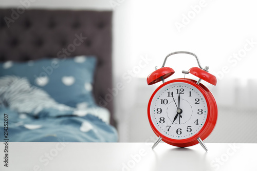 Quadro em tela Analog alarm clock on table in bedroom. Time of day