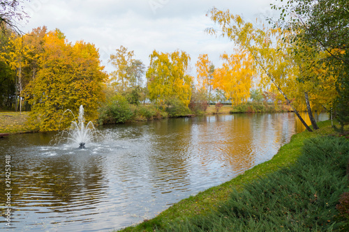 Wallpaper Mural A small decorative fountain in the middle of a transparent lake against the backdrop of beautiful autumn trees Torontodigital.ca