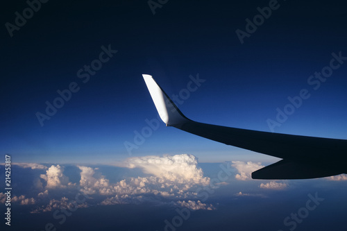 View from a window of passenger plane during flight above clouds