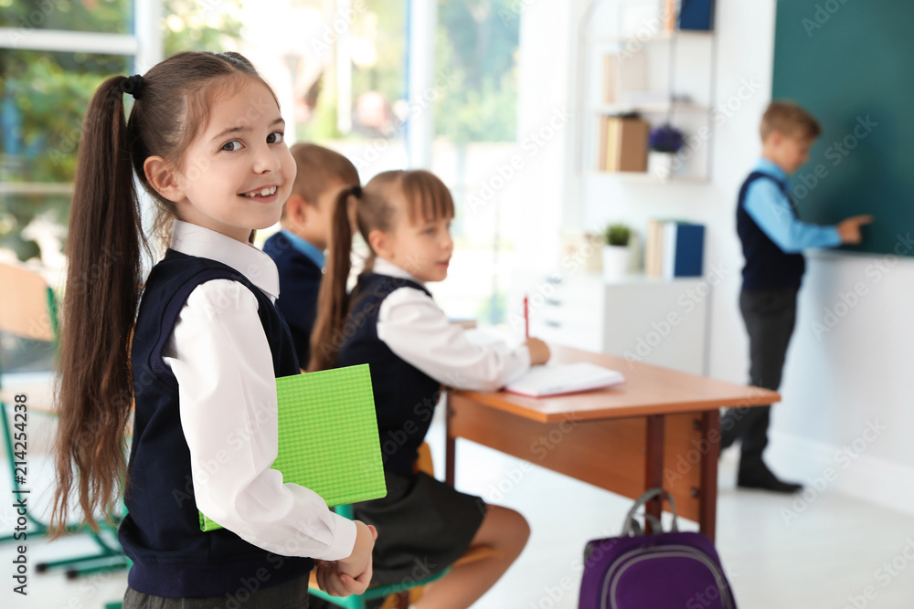 Little girl in classroom. Stylish school uniform Little girl in classroom. Stylish school uniform