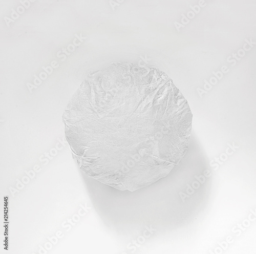 Classic burger packed in the wrapping paper on white background. Top view.