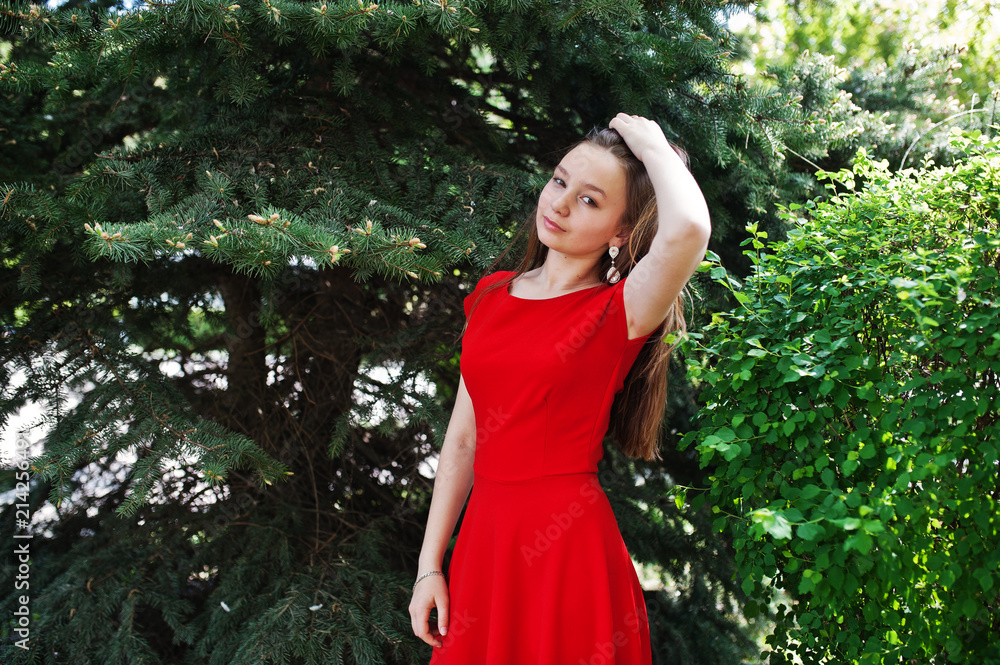 Teenage girl in red dress posed outdoor at sunny day. Teenage girl in red dress posed outdoor at sunny day.