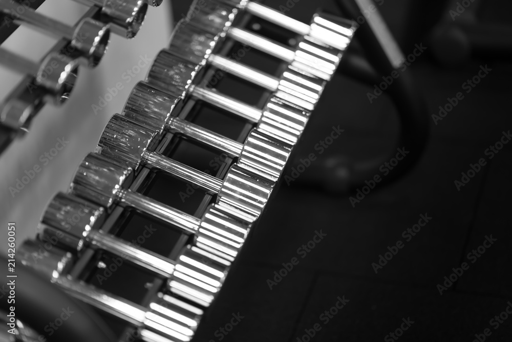 Rows of silver dumbbells in the gym. monochrome photo Rows of silver dumbbells in the gym. monochrome photo