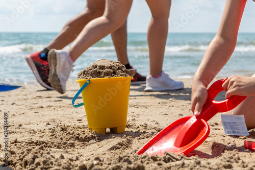 Lek med hink och spade på sandstrand vid havet photo