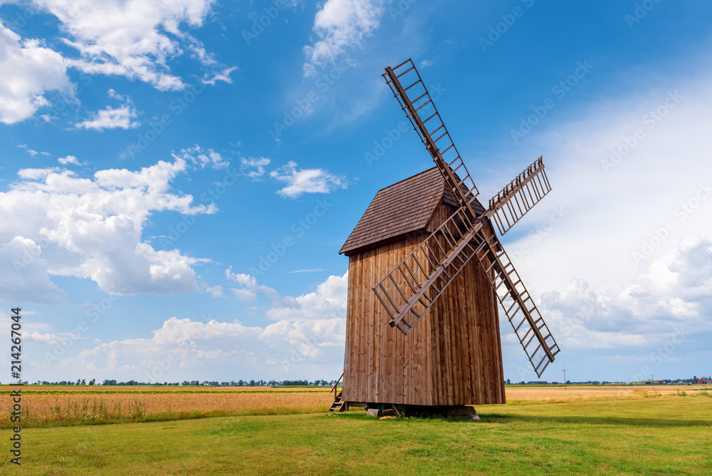 Old wooden windmill on field in summer day. Poland
