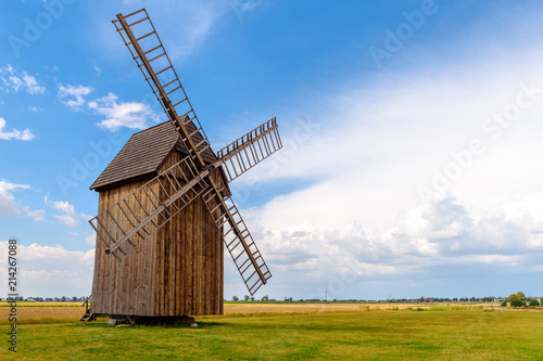 Old wooden windmill on field in summer day. Poland