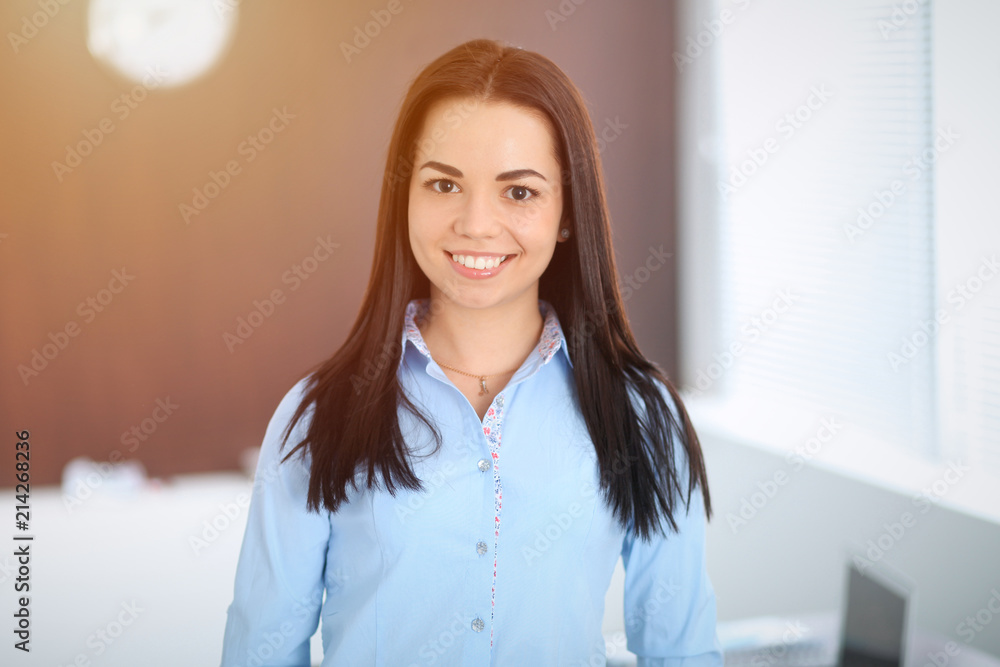 Young brunette business woman looks like a student girl working in office. Hispanic or latin american girl standing straight Young brunette business woman looks like a student girl working in office. Hispanic or latin american girl standing straight