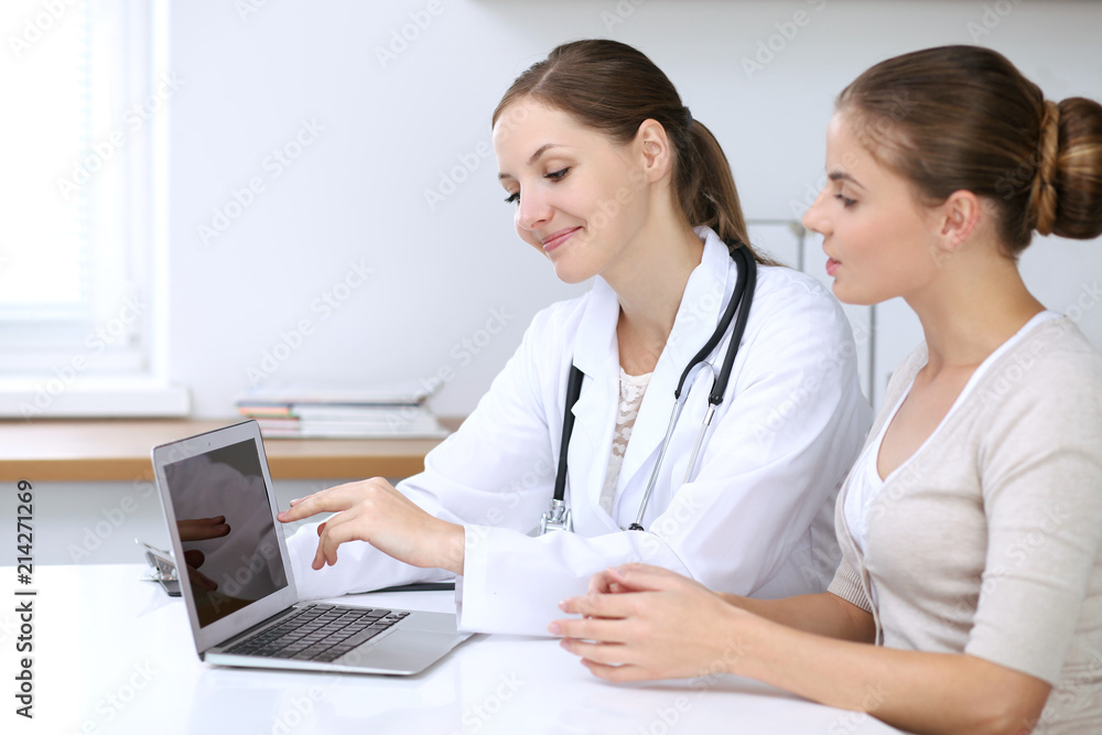 Doctor and patient having a pleasure talk while sitting at the desk at hospital office. Healthcare and medicine concept Doctor and patient having a pleasure talk while sitting at the desk at hospital office. Healthcare and medicine concept