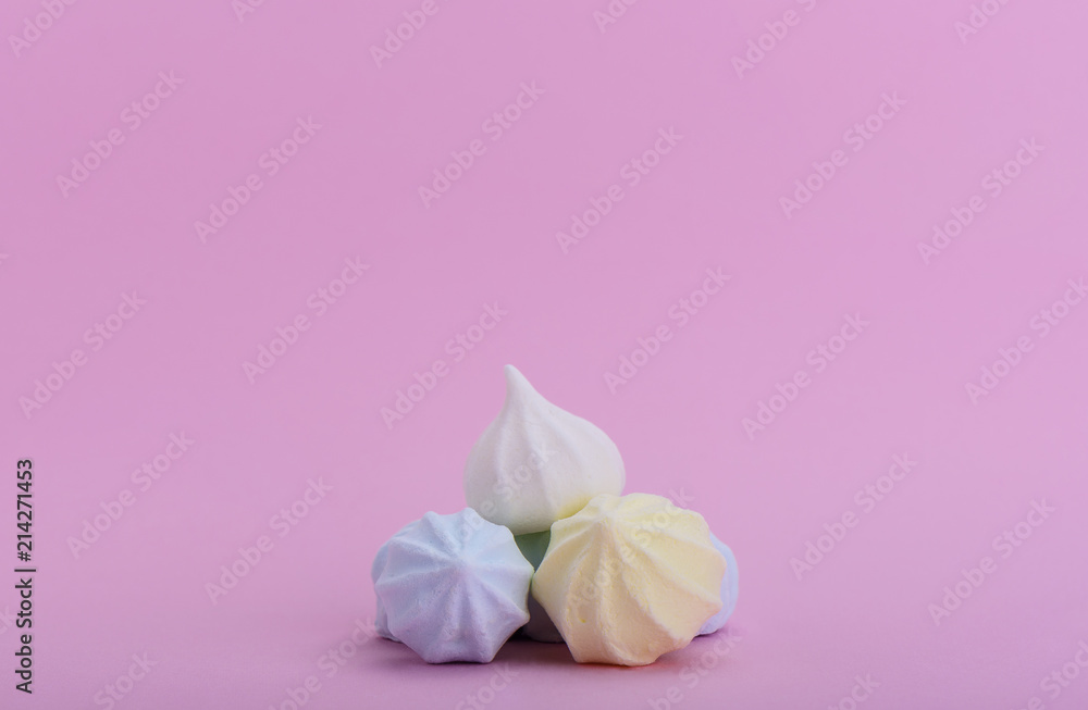 Pyramid of multicolored meringues on a pink background
