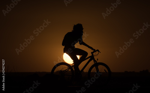 Silohuette of a bike at sunset © nickalbi