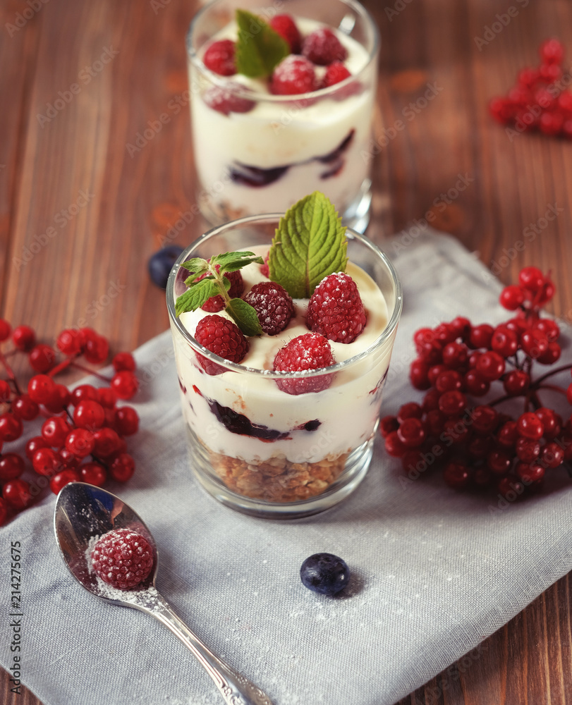 Happy breakfast - yogurt with muesli and berries on a wooden table
