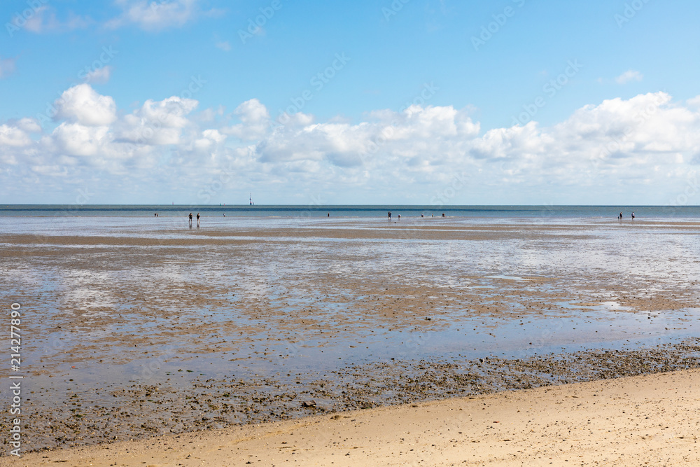 north sea beach with blue sky and clouds