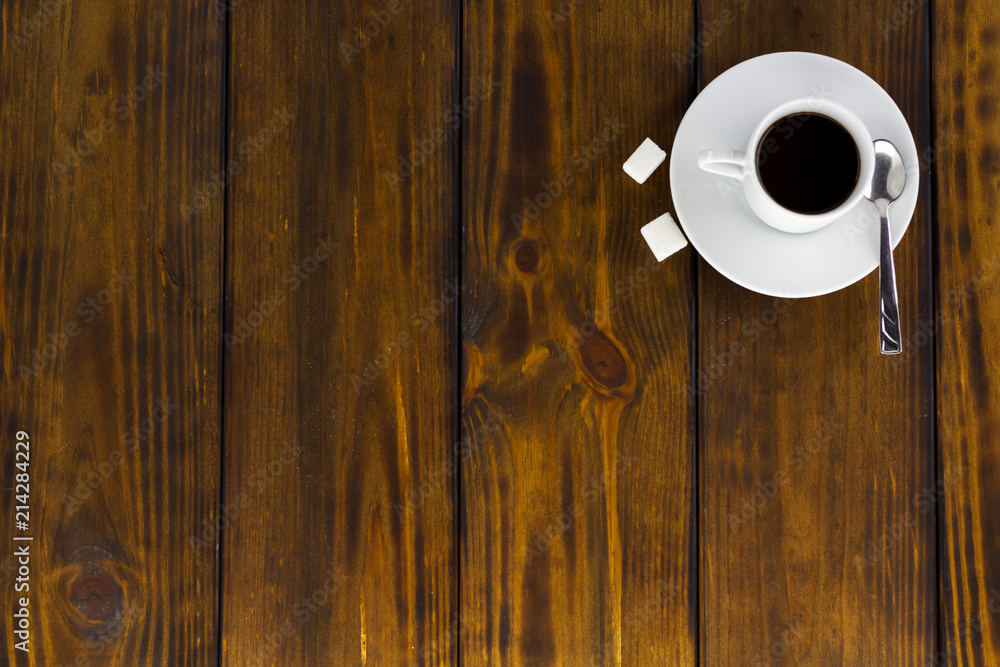 Black coffee with 2 sugars, white cup on a brown wooden table. Top view Black coffee with 2 sugars, white cup on a brown wooden table. Top view