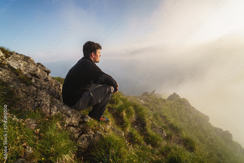 Wanderer auf Berggipfel blickt in die Sonne Wanderer auf Berggipfel blickt in die Sonne