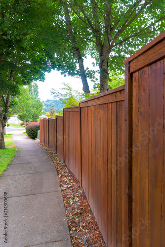 Wooden stained Fence along suburban Neighborhood Sidewalk