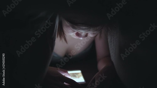 Beautiful women are using the phone. On the sofa in the bedroom