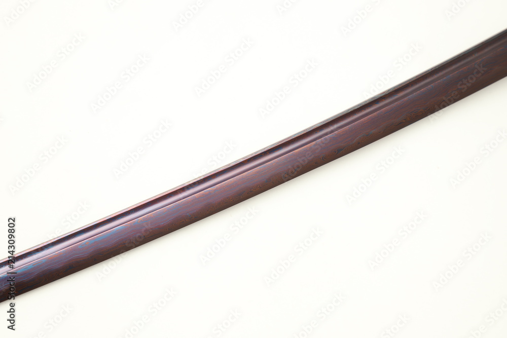Folded steel blade of Japanese sword (Chinese made) red color by titanium coated isolated in white background Folded steel blade of Japanese sword (Chinese made) red color by titanium coated isolated in white background
