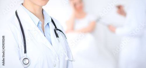 Unknown female doctor with medical staff at hospital. Closeup of stethoscope