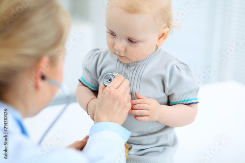 Doctor and patient in hospital. Little girl is being examined by pediatrician with stethoscope. Medicine and health care