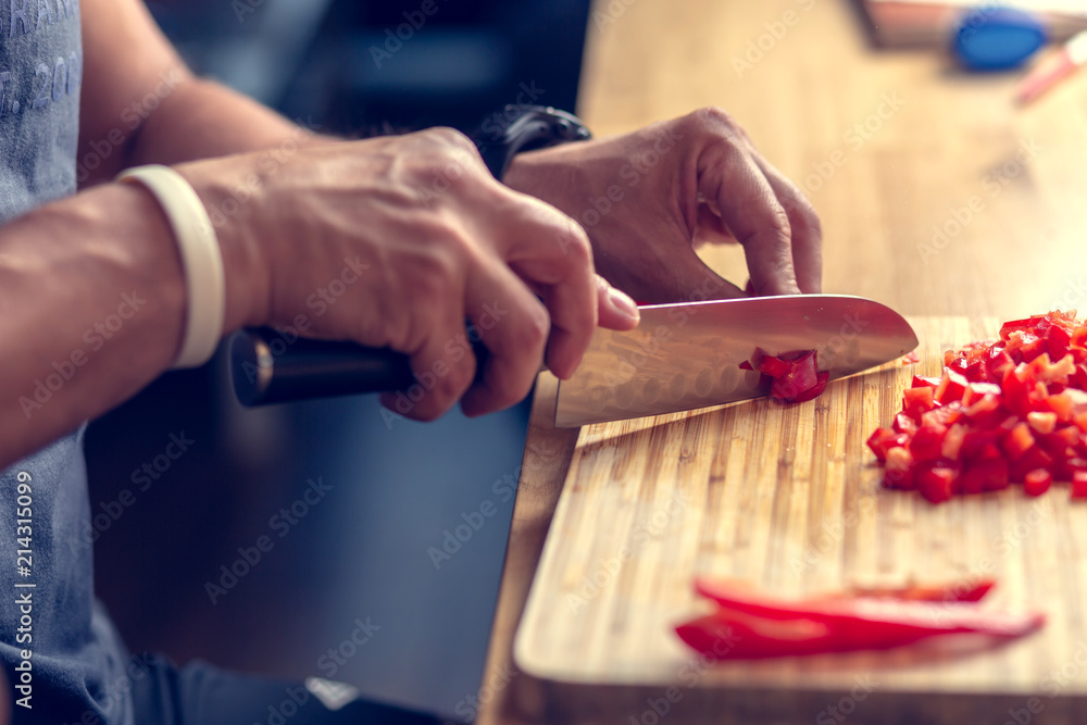 Chopping vegetables on a wooden board at home. Shallow depth of field. Chopping vegetables on a wooden board at home. Shallow depth of field.