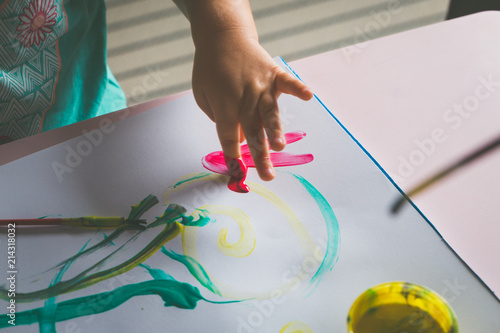 Little girl hand, who is painting with her finger.